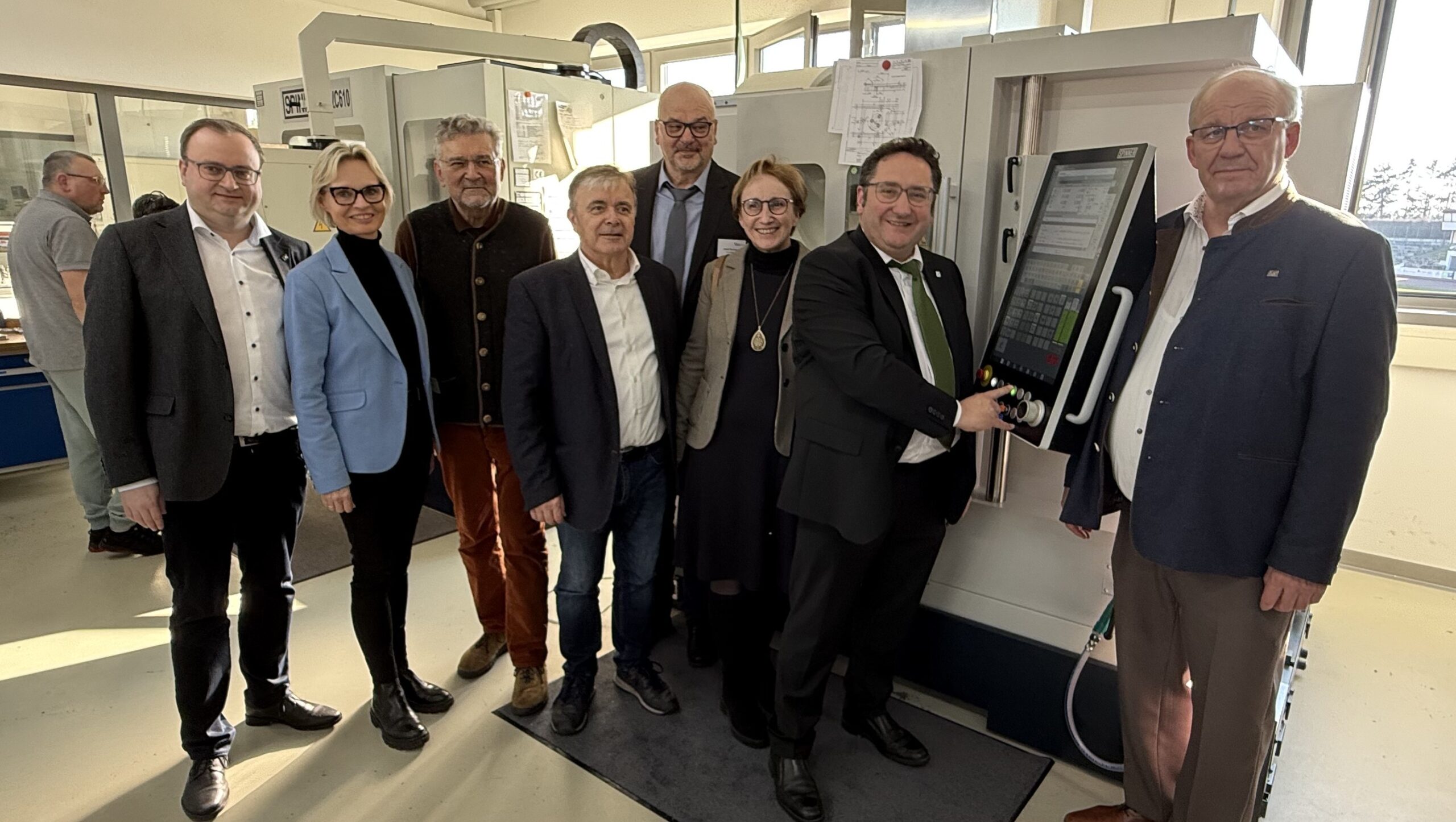 Staatssekretär Tobias Gotthardt (2.v.r.) drückt den Startknopf des CNC-Bearbeitungszentrums. Die Einweihung der Maschine begleiten (v.r.): MdL Christian Lindinger, MdL Roswitha Toso, Geschäftsführer des ebiz Josef Neubauer, 1. Bürgermeister und Aufsichtsrat des ebiz Franz Krah, Aufsichtsratsvorsitzender des ebiz Wilhelm Mixa, Stellvertreterin des Landrates Cornelia Wasner-Sommer, MdL Stefan Meyer.